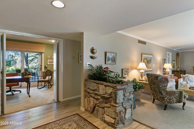 living room with crown molding and light hardwood / wood-style floors