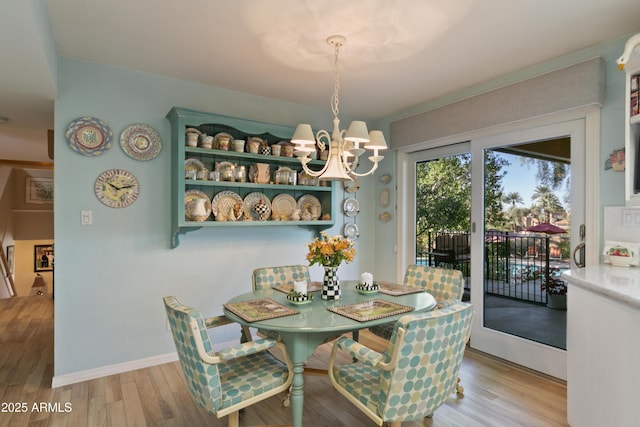 dining area with hardwood / wood-style flooring and a notable chandelier