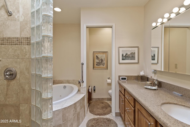 bathroom with tiled tub, toilet, and vanity