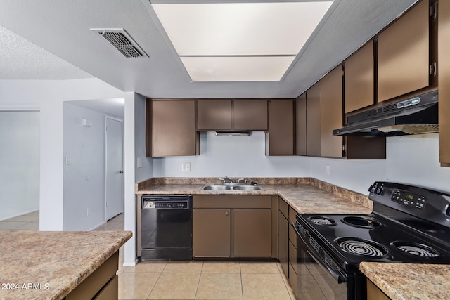 kitchen featuring light tile patterned floors, a textured ceiling, black appliances, and sink