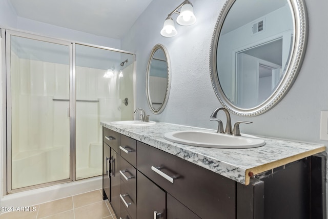 bathroom with vanity, tile patterned floors, and a shower with door