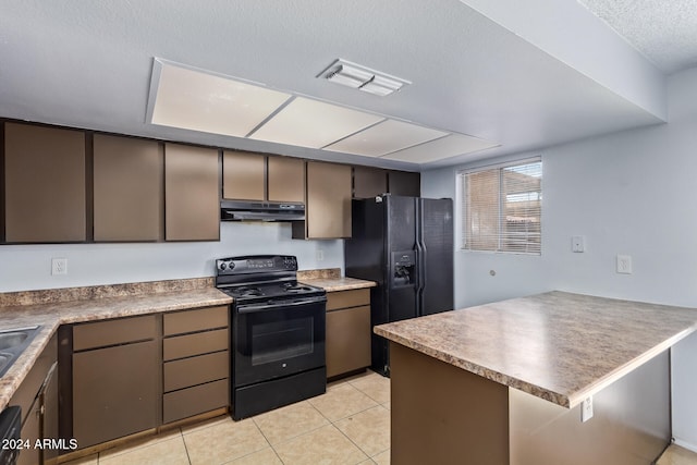 kitchen featuring black appliances, light tile patterned flooring, kitchen peninsula, and a textured ceiling