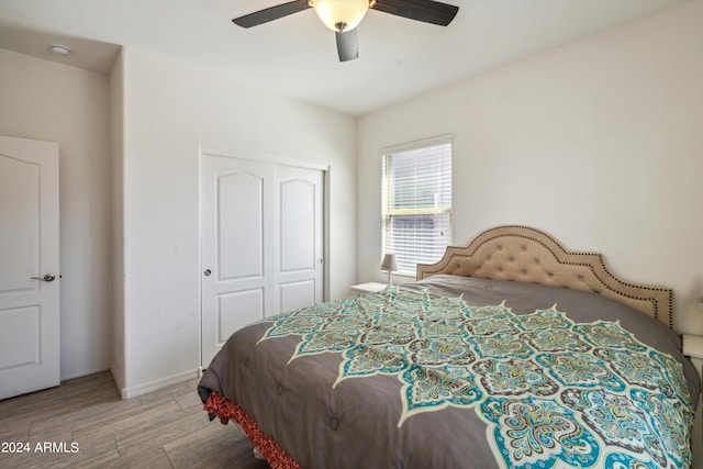 bedroom featuring ceiling fan, a closet, and hardwood / wood-style flooring