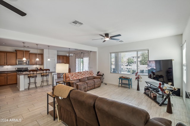 living room featuring ceiling fan and light hardwood / wood-style floors