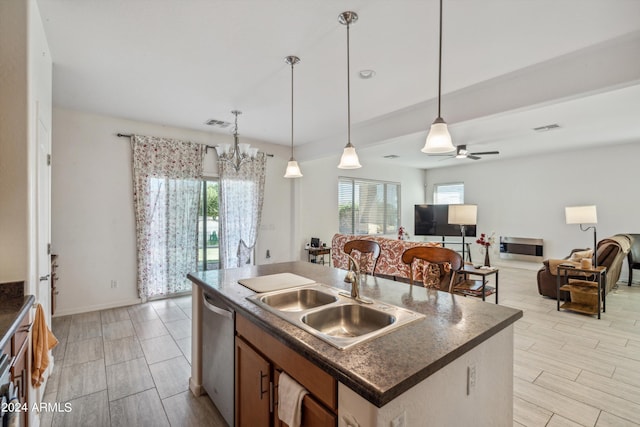 kitchen featuring light hardwood / wood-style flooring, ceiling fan with notable chandelier, sink, an island with sink, and stainless steel dishwasher