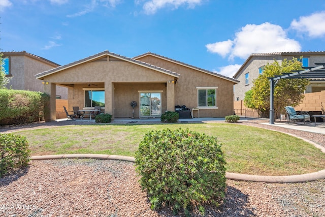 rear view of property with a pergola, a lawn, and a patio