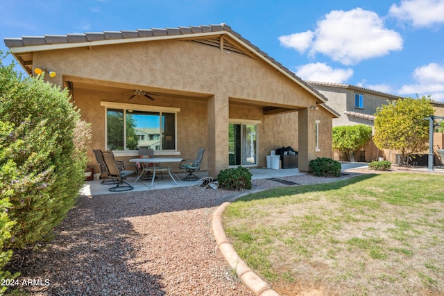 rear view of house with a yard, ceiling fan, and a patio