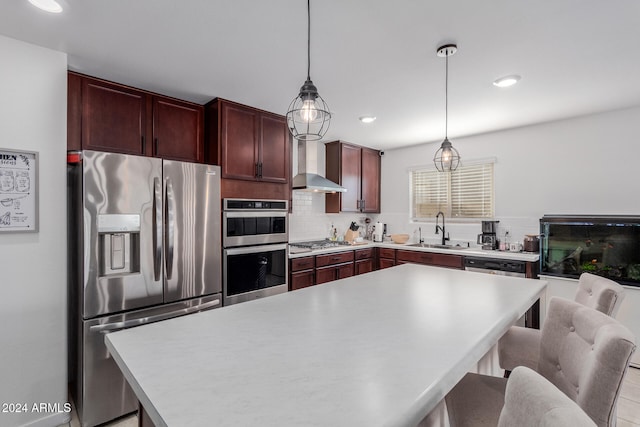 kitchen featuring appliances with stainless steel finishes, tasteful backsplash, wall chimney exhaust hood, hanging light fixtures, and a center island