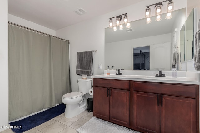 bathroom with toilet, vanity, and tile patterned floors