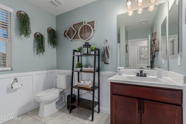 bathroom with tile patterned flooring, vanity, and toilet