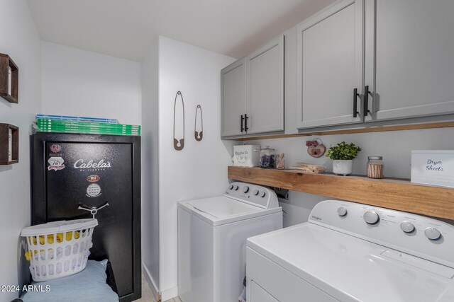 washroom featuring cabinets and washer and clothes dryer