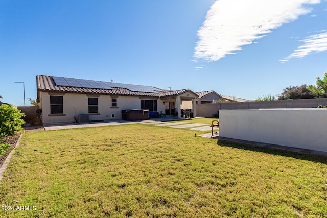 back of property featuring a patio, central AC, solar panels, and a lawn