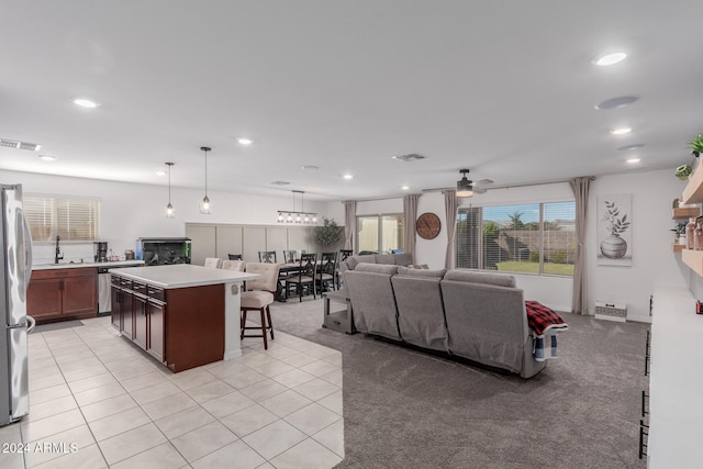 living room with sink, light tile patterned floors, and ceiling fan