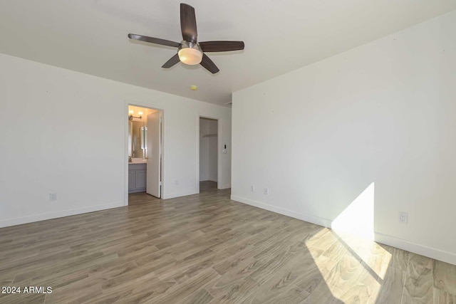 unfurnished bedroom with wood-type flooring, ceiling fan, and ensuite bathroom