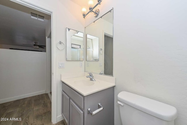 bathroom with wood-type flooring, vanity, toilet, and ceiling fan