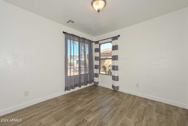 empty room with dark hardwood / wood-style flooring