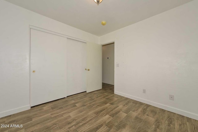 unfurnished bedroom with wood-type flooring and a closet