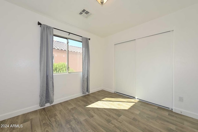 unfurnished bedroom with a closet and hardwood / wood-style floors