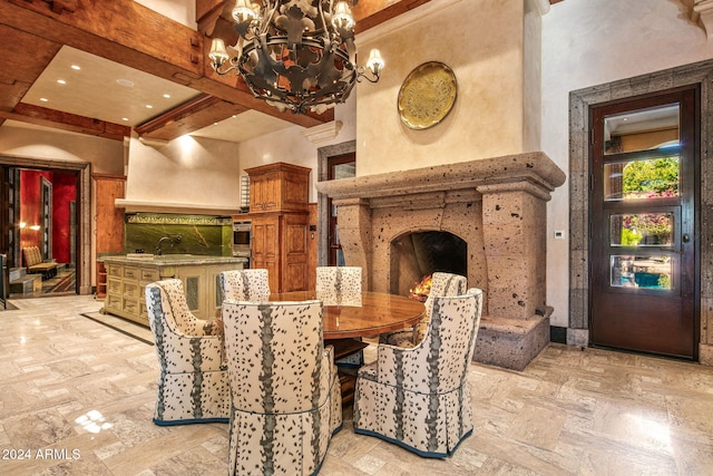 dining area featuring a towering ceiling, a chandelier, and beam ceiling