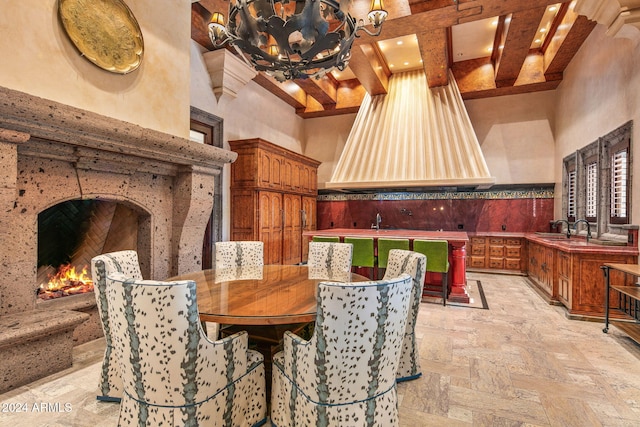 dining area with a towering ceiling, sink, and beam ceiling