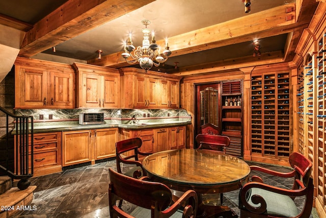 kitchen featuring a notable chandelier, beamed ceiling, and tasteful backsplash