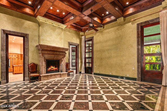 interior space with a towering ceiling, beam ceiling, ceiling fan, and coffered ceiling