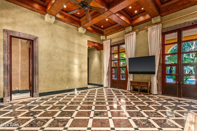 unfurnished living room featuring french doors, coffered ceiling, beamed ceiling, wooden ceiling, and ceiling fan