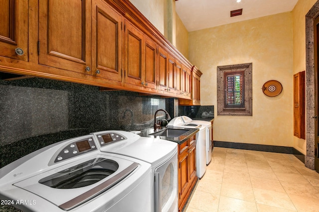 laundry room featuring washer and clothes dryer, cabinets, sink, and light tile patterned flooring