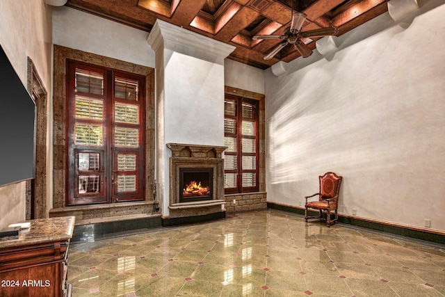 unfurnished room with a high ceiling, coffered ceiling, ceiling fan, and beam ceiling