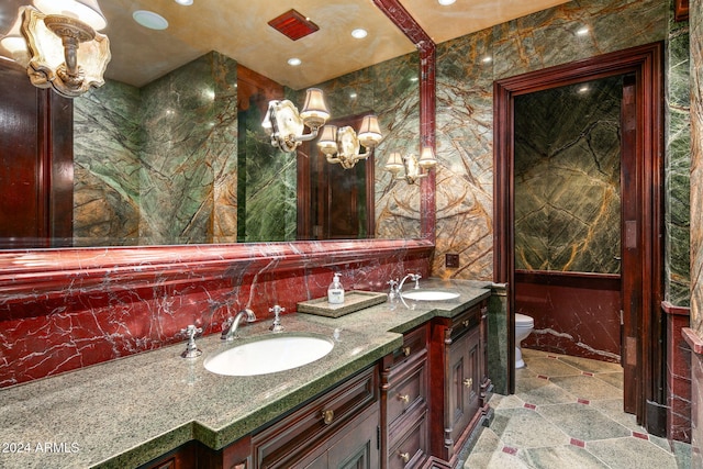 8100 N 68th St, Paradise Valley, AZ 85253 - bathroom featuring double vanity, toilet, a chandelier, recessed lighting, and tile walls