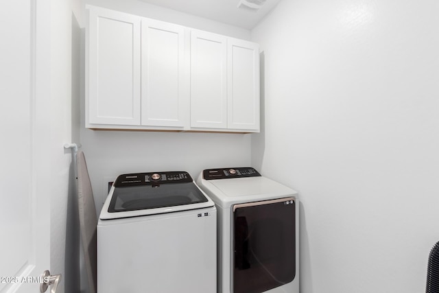 washroom with cabinets and washing machine and clothes dryer