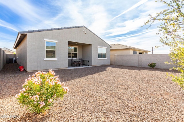 rear view of property with central AC unit and a patio