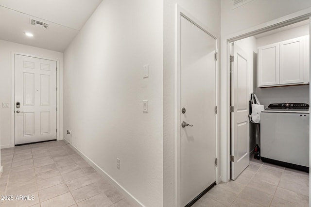 hall featuring washer / clothes dryer and light tile patterned flooring