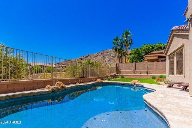 view of swimming pool featuring a patio and a mountain view