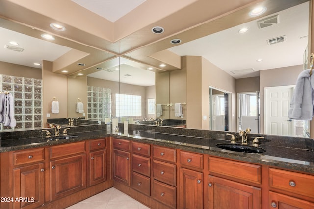 kitchen featuring dark stone countertops, a wealth of natural light, and sink