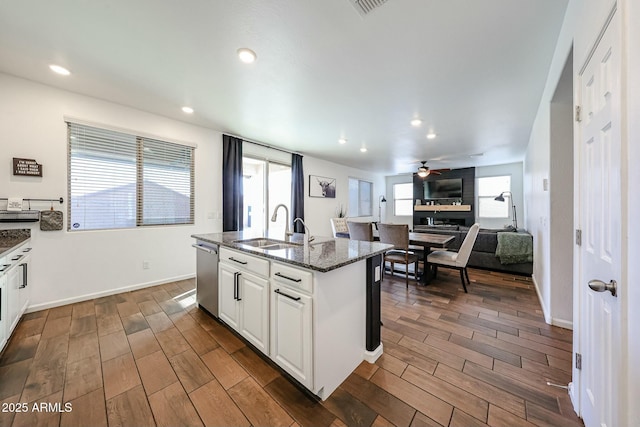 1713 W Cottonwood Ln, Phoenix, AZ 85045 - kitchen with dark stone counters, a sink, a kitchen island with sink, wood finish floors, and stainless steel dishwasher