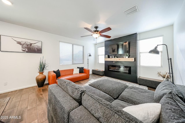 1713 W Cottonwood Ln, Phoenix, AZ 85045 - living room with visible vents, a ceiling fan, a large fireplace, wood finished floors, and baseboards