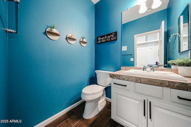 1713 W Cottonwood Ln, Phoenix, AZ 85045 - bathroom featuring a textured wall, toilet, wood tiled floor, vanity, and baseboards