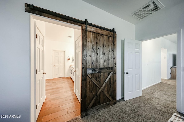 1713 W Cottonwood Ln, Phoenix, AZ 85045 - hallway with wood finished floors, visible vents, baseboards, and a barn door