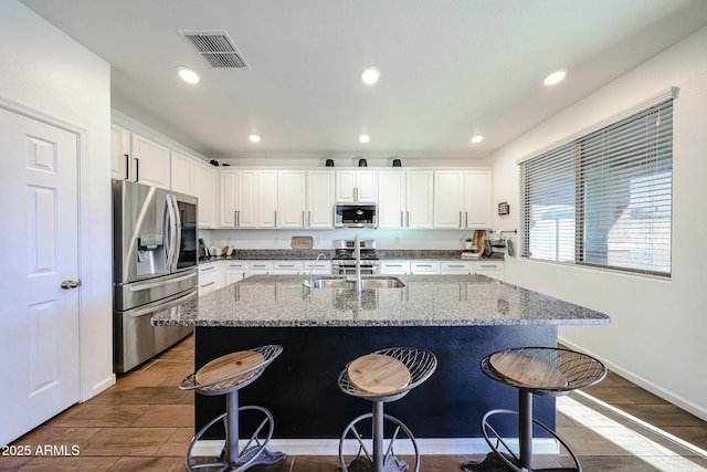 1713 W Cottonwood Ln, Phoenix, AZ 85045 - kitchen featuring a sink, stainless steel appliances, a kitchen bar, and visible vents