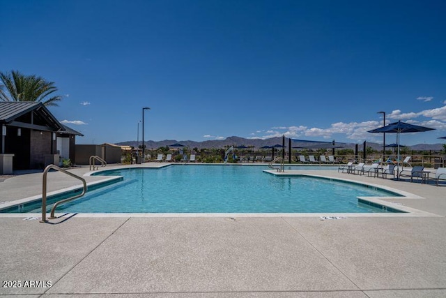 community pool with a patio area and a mountain view