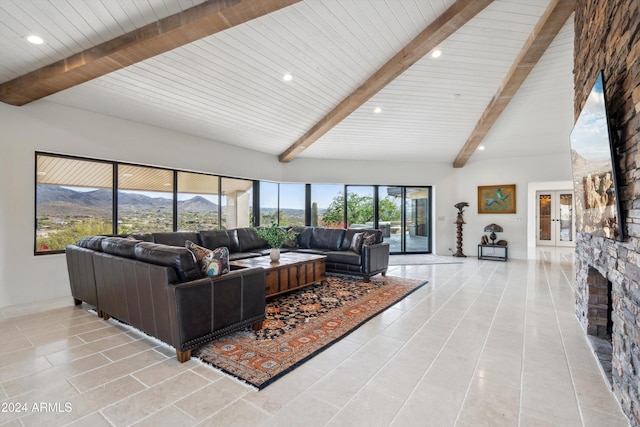 living room with a mountain view, a stone fireplace, wooden ceiling, and light tile patterned flooring