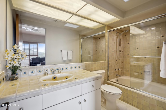 full bathroom with tile patterned flooring, vanity, tiled shower / bath combo, and toilet