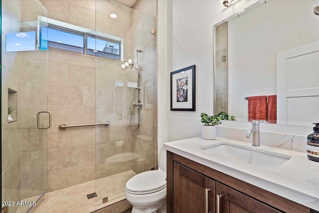 bathroom featuring vanity, toilet, and an enclosed shower