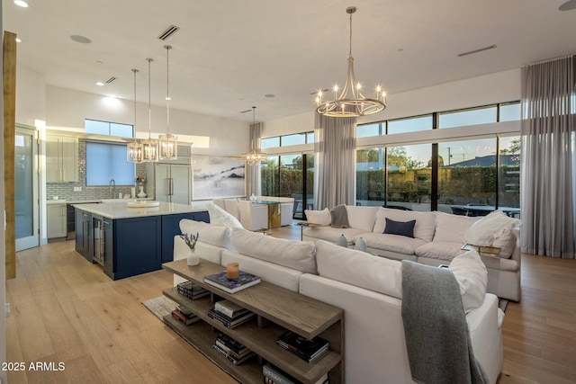 living room with a chandelier, light wood-style flooring, healthy amount of natural light, and recessed lighting