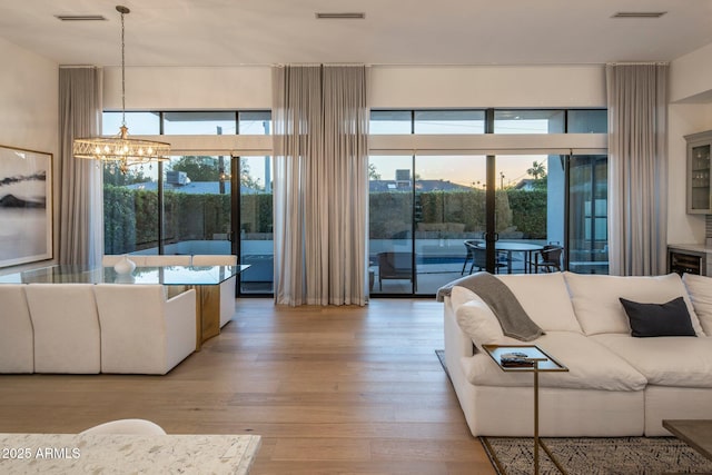 living room featuring a chandelier and light wood-type flooring