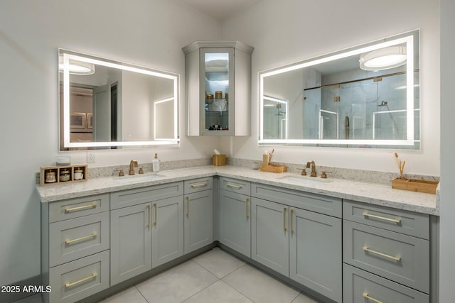 full bathroom featuring double vanity, a shower stall, and tile patterned flooring