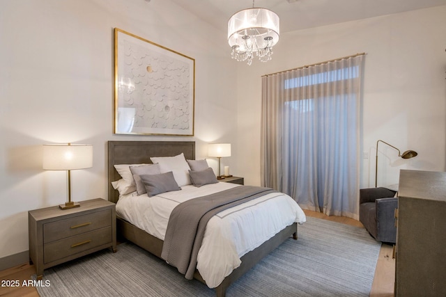 bedroom with a chandelier and wood finished floors