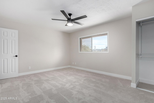 unfurnished bedroom with ceiling fan, light colored carpet, a closet, and a textured ceiling