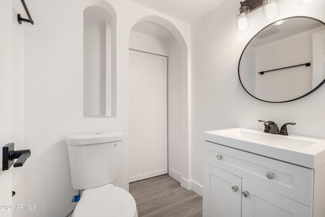 bathroom with vanity, hardwood / wood-style floors, and toilet